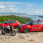 1 motocyclette et 2 automobiles de l'auto-moto école Cristale à la Seyne-sur-Mer sur un parking surplombant la rade de Toulon