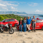 L'équipe de 4 moniteurs de l'auto-moto école Cristale à la Seyne-sur-Mer devant 1 motocyclette et 2 automobiles sur un parking surplombant la rade de Toulon